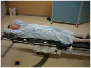 仰臥位にて放射線治療を受ける人の写真